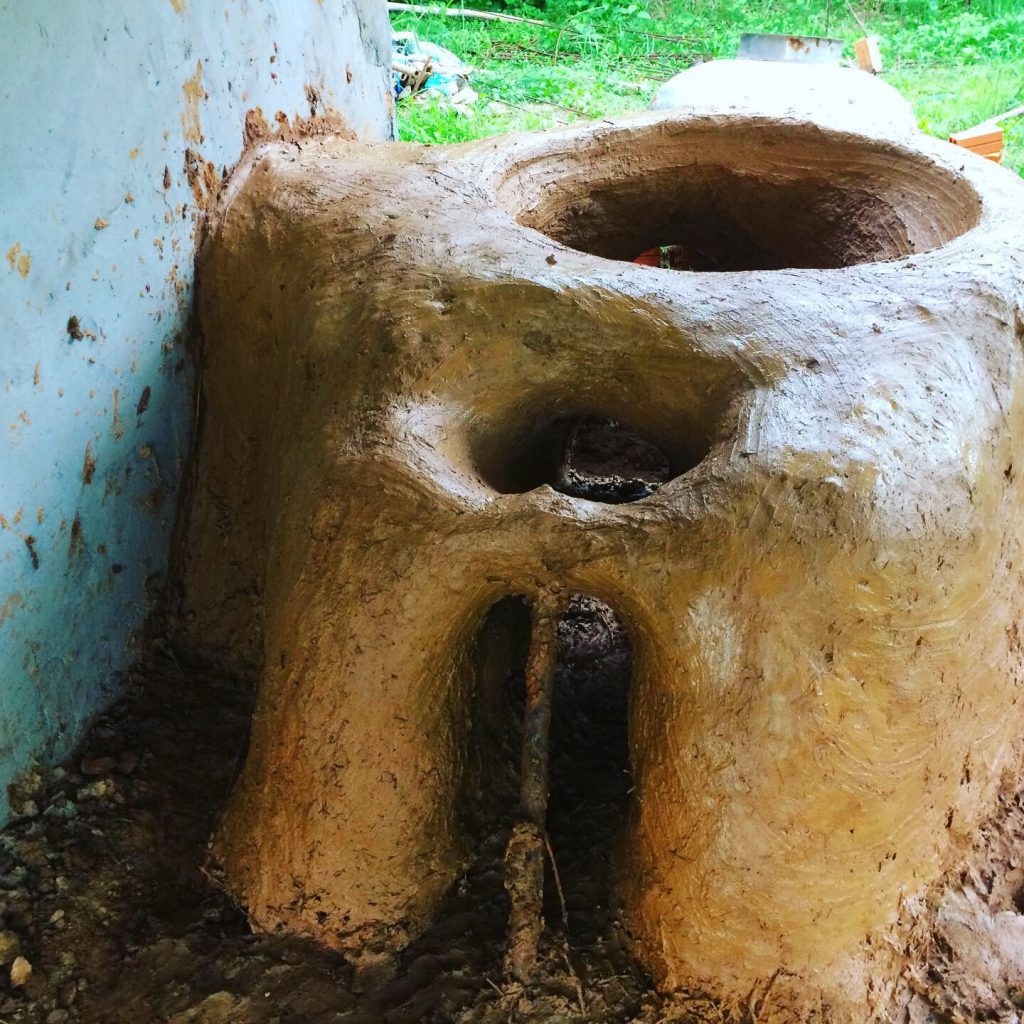 Hand-built cob earthen rocket stove made from natural clay at the Red Road Foundation