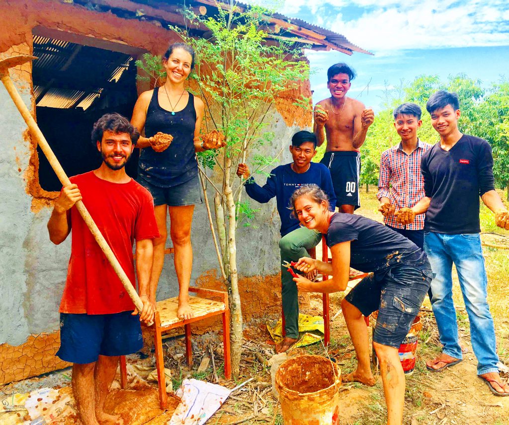 International interns and local Cambodians building a natural cob structure together at the Red Road Foundation